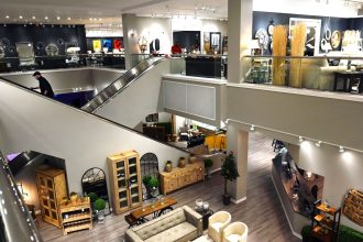 In this 2020 photo, a worker goes up an escalator at Jordan's Furniture Store at the Maine Mall in South Portland, Maine.