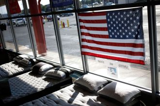 In this June 2022 photo, a US flag is seen above mattresses at Charlie Wilson's appliance and TV store in Clarksville, Indiana.