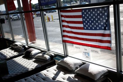 In this June 2022 photo, a US flag is seen above mattresses at Charlie Wilson's appliance and TV store in Clarksville, Indiana.