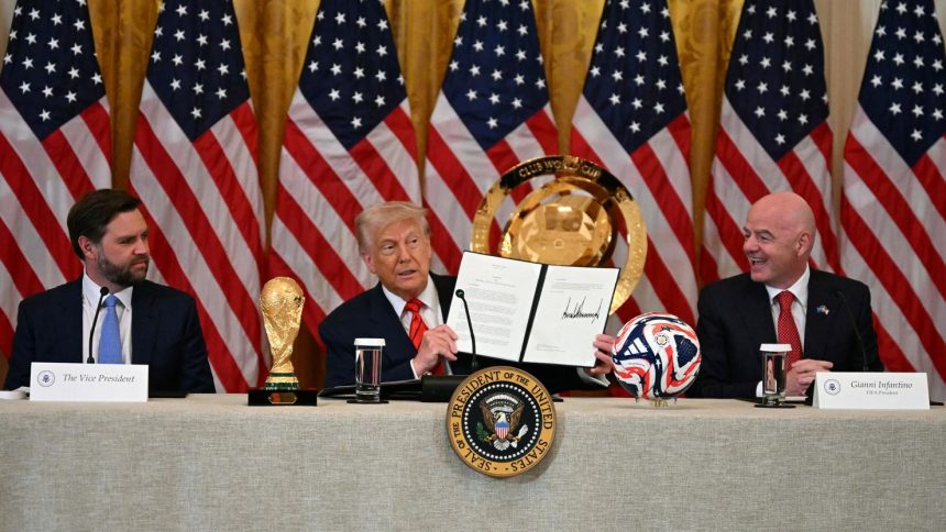 President Donald Trump holds up a document creating the "White House Task Force on the FIFA World Cup 2026" as US Vice President JD Vance, left, and FIFA president Gianni Infantino look on in the East Room of the White house in Washington, DC, on May 6.