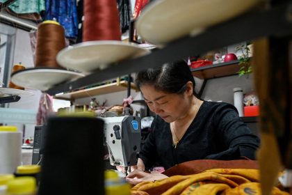 A woman sews clothing at the Keqiao China Textile City, one of the biggest textile markets in Asia, in Shaoxing in China's eastern Zhejiang province on May 8.