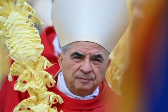 Italian Cardinal Giovanni Angelo Becciu takes par in the procession of the Palm Sunday mass on April 2, 2023 at St. Peter's Square in the Vatican.