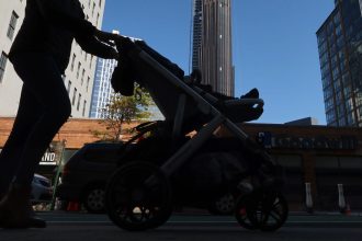 A woman pushes a stroller in front of the Brooklyn Tower on October 9, 2022, in New York City.