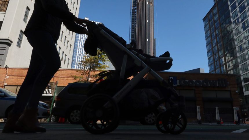 A woman pushes a stroller in front of the Brooklyn Tower on October 9, 2022, in New York City.