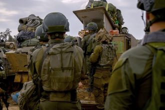 Reservists prepare their belongings before entering Gaza at a staging point near the Gaza border, in southern Israel on December 14, 2023.