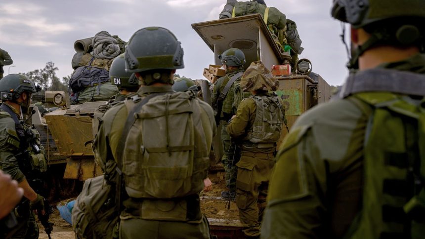 Reservists prepare their belongings before entering Gaza at a staging point near the Gaza border, in southern Israel on December 14, 2023.