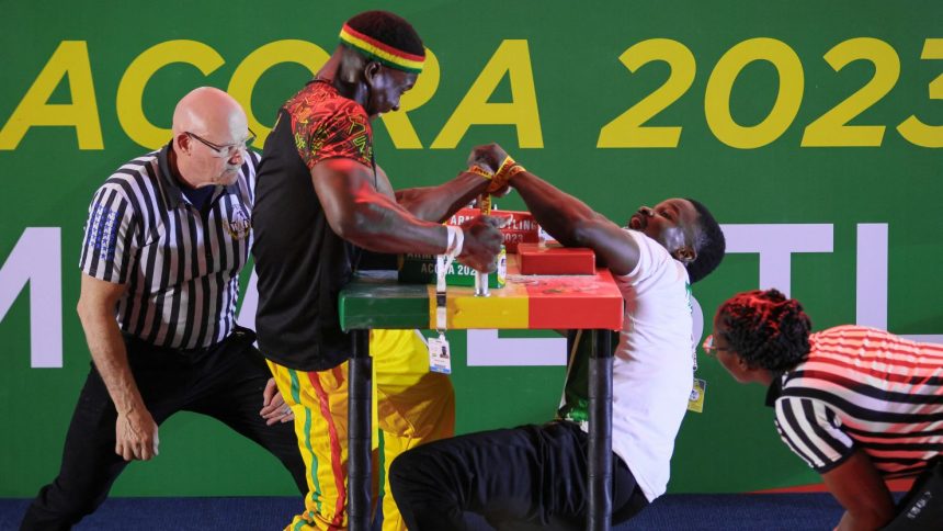 Ghana's Prince Affum (left) competes against Nigeria's Samual Nneka (R) in the Senior Men's 85KG left arm wrestling competition during the 13th African Games in Accra, Ghana in March 2024.