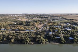 An aerial view shows agricultural land to the right, the Orange River and Orania, an "Afrikaner-only" town in South Africa's Northern Cape, on May 26, 2024.