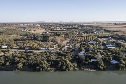 An aerial view shows agricultural land to the right, the Orange River and Orania, an "Afrikaner-only" town in South Africa's Northern Cape, on May 26, 2024.