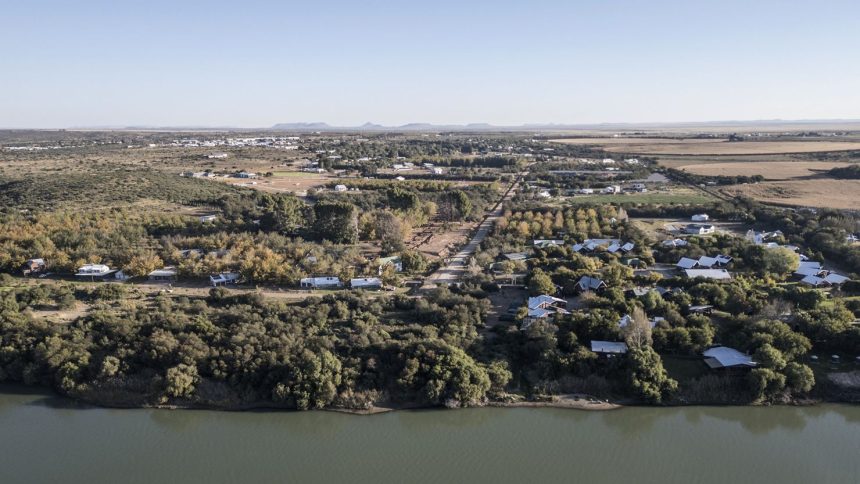 An aerial view shows agricultural land to the right, the Orange River and Orania, an "Afrikaner-only" town in South Africa's Northern Cape, on May 26, 2024.