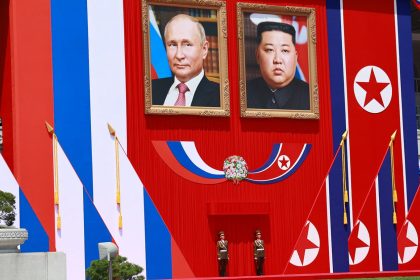 Two guards stand underneath portraits of North Korean leader Kim Jong Un and Russian President Vladimir Putin during a welcome ceremony during Putin's visit to Pyongyang on June 19, 2024.