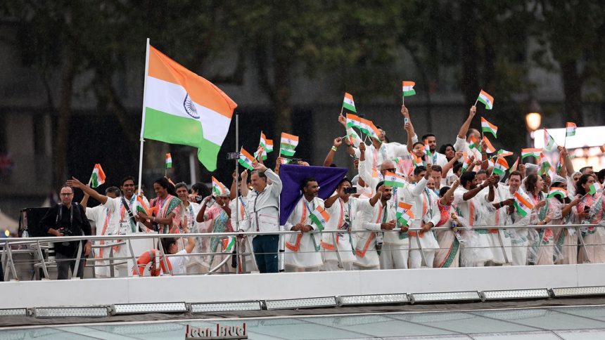 Sharath Kamal Achanta and V. Sindhu Pusarla, flagbearers of Team India, wave their national flag during the opening ceremony of the Olympic Games in Paris on July 26, 2024.