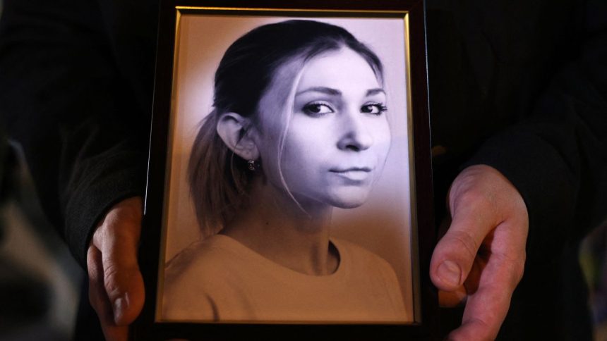A colleague of Ukrainian journalist Victoria Roshchyna holds a photograph of her during an event in honor of her memory in Kyiv, on October 11, 2024.