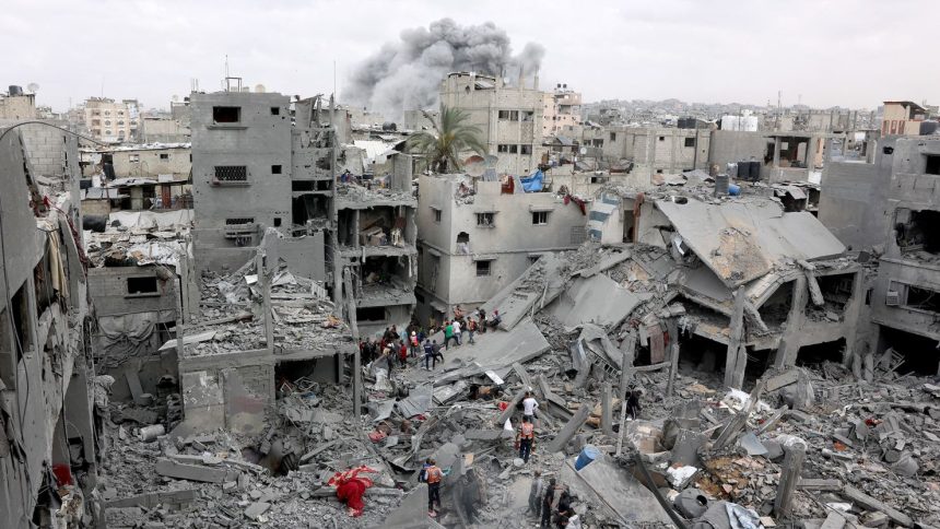 Palestinian rescuers check the site of Israeli bombardment on a residential building in Gaza City's Shujaiyya neighborhood on April 9.