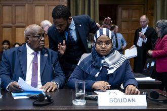 Muawia Osman Mohamed Khair (L), Sudan's acting justice minister, and Sudanese ambassador to the Netherlands Omaima Alsharief, wait for the start of a hearing before the International Court of Justice in The Hague, on Thursday.