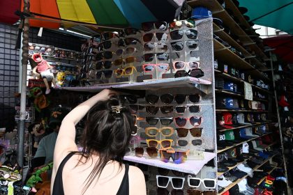 A shopper looks at sunglasses made in China at Santee Alley, in Los Angeles' Fashion District, known for inexpensive imported garments and accessories.