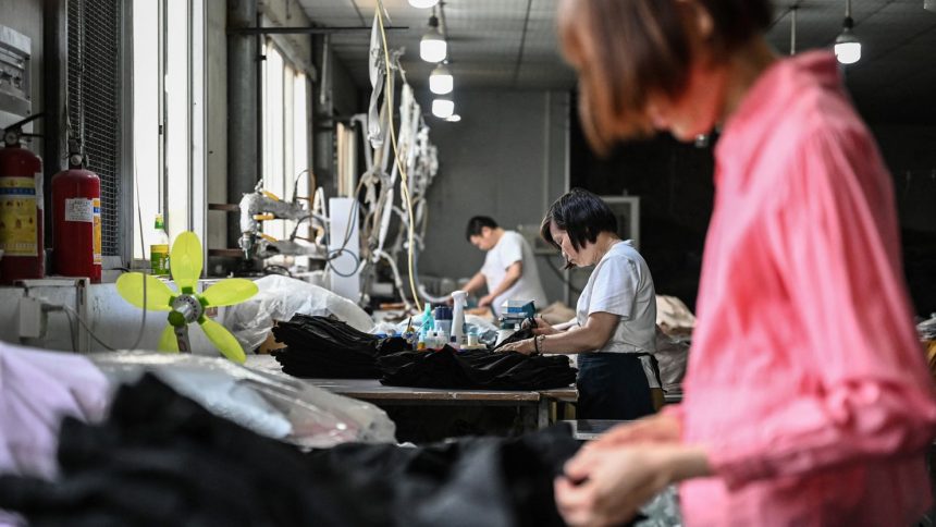 Employees produce garments for the online Chinese e-commerce company Temu at a clothing factory in Guangzhou in southern China's Guangdong province on April 16.