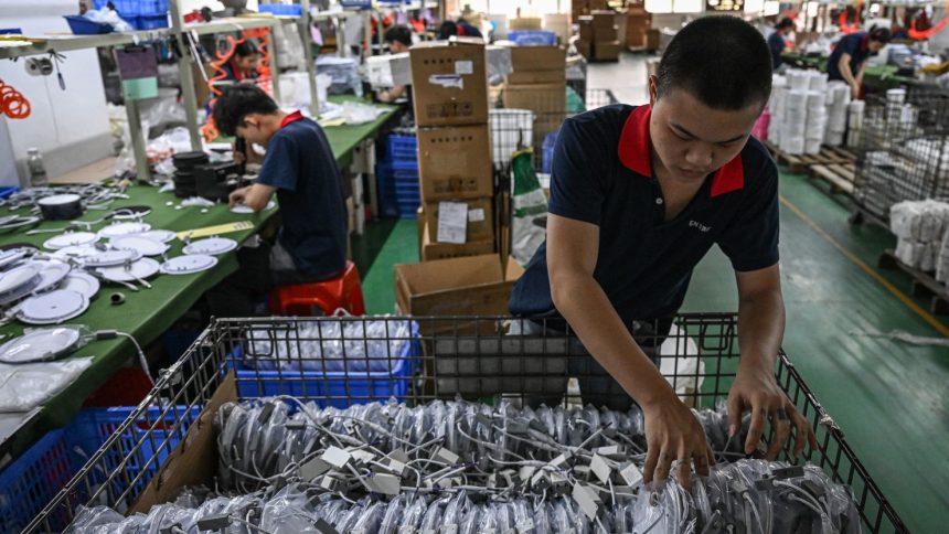 Employees work at a factory producing LED lights in Zhongshan, in southern China's Guangdong province on April 17, 2025.