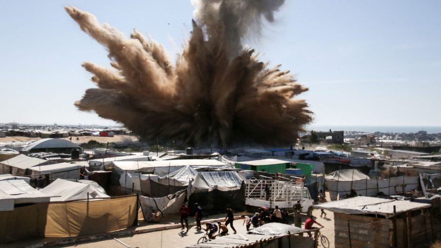 People run for cover from an Israeli strike on tents for displaced Palestinians in northern Khan Younis, southern Gaza, on April 19.