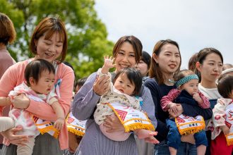 Parents hold their children before the start of their "crying baby sumo" match at the Sensoji temple in Tokyo on April 26, 2025.