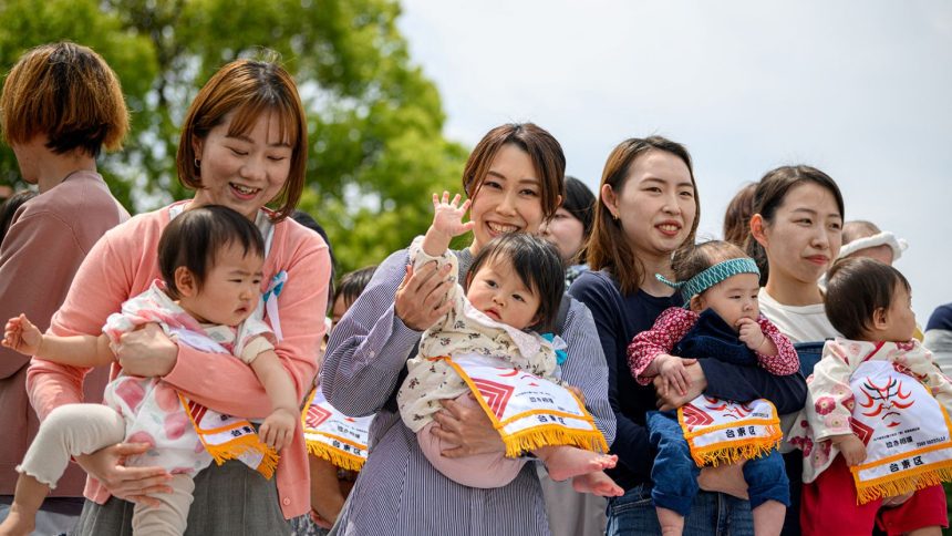 Parents hold their children before the start of their "crying baby sumo" match at the Sensoji temple in Tokyo on April 26, 2025.