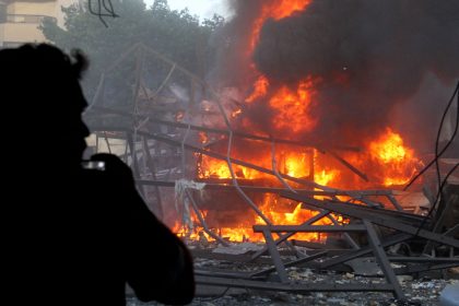 A man takes pictures of the aftermath of Israeli strikes in Beirut's southern suburb on April 27, 2025.