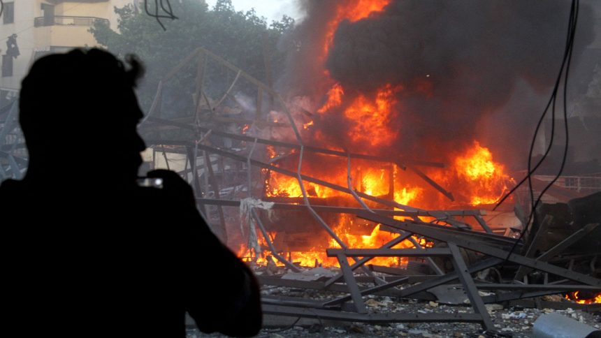 A man takes pictures of the aftermath of Israeli strikes in Beirut's southern suburb on April 27, 2025.