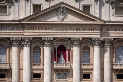 Red drapes are installed Monday on the main balcony of St. Peter's Basilica, where the new pope will be introduced to the world.