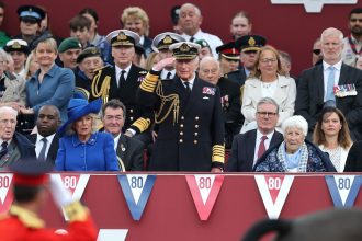 King Charles salutes a military procession to mark the 80th anniversary of VE Day in London.