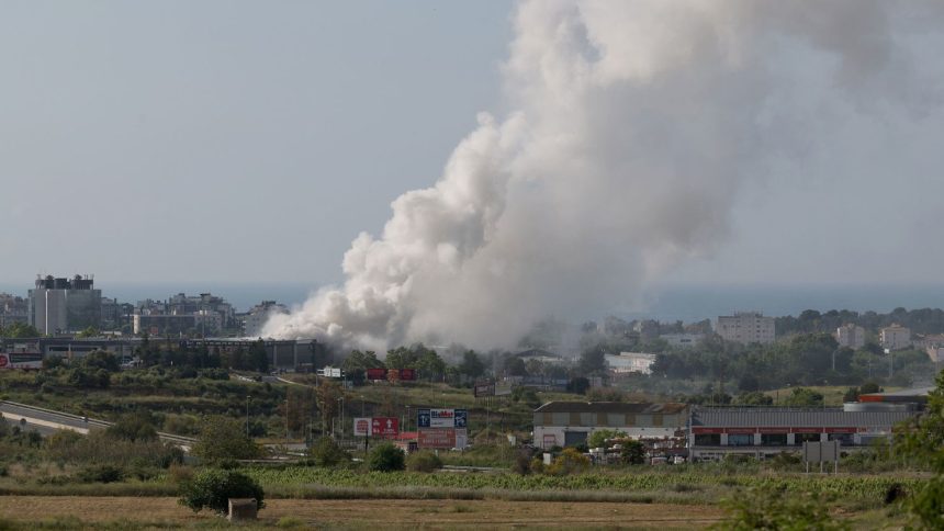 Smoke billows from a building storing pool cleaning products in the coastal city of Vilanova i la Geltru, Spain, on Saturday.