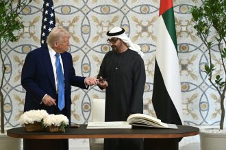 US President Donald Trump returns the pen to his UAE counterpart Sheikh Mohamed bin Zayed Al Nahyan, after signing the guest book at Qasr Al-Watan in Abu Dhabi on Thursday.
