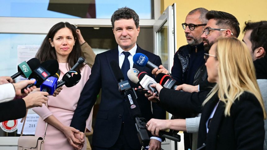 Bucharest Mayor and independent presidential candidate Nicusor Dan and his wife Mirabela Gradinaru are seen after voting at a polling station in Fagaras, central Romania on May 18, 2025.