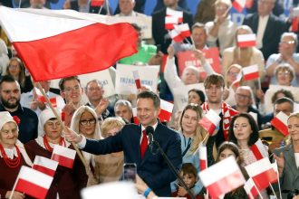Presidential candidate, Rafal Trzaskowski, waves the Polish flag as he speaks to supporters after first exit polls following Presidential elections are announced in Sandomierz, on May 18, 2025.