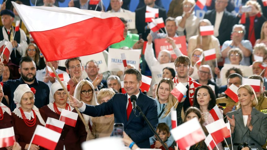 Presidential candidate, Rafal Trzaskowski, waves the Polish flag as he speaks to supporters after first exit polls following Presidential elections are announced in Sandomierz, on May 18, 2025.