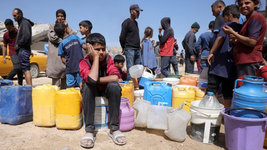 Palestinians attempt to collect water at a camp for displaced people in Gaza City, on May 20, 2025 amid Israel's military operation in the enclave.