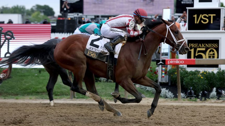 Jockey Umberto Rispoli crosses the finish line on Journalism #2 to win the 150th Preakness Stakes at Pimlico Race Course in Baltimore, Maryland.
