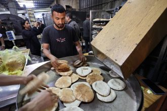 Employees of a bakery in Deir el-Balah fill bags with freshly-baked bread on Thursday, after Israel allowed limited humanitarian aid to enter Gaza.