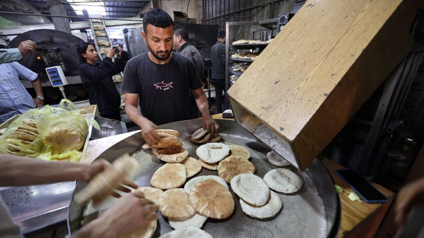 Employees of a bakery in Deir el-Balah fill bags with freshly-baked bread on Thursday, after Israel allowed limited humanitarian aid to enter Gaza.