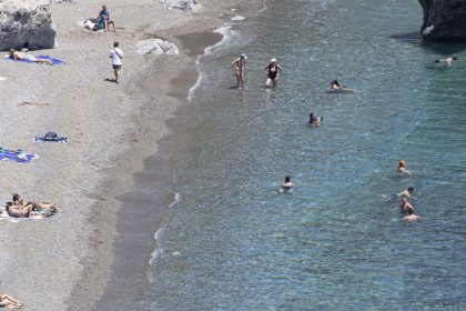 Tourists enjoy the summer sun at the sandy beach at Preveli, a popular tourist destination in the Mediterranean sea with the freshwater river, the palm tree forest and the entrance of the rocky gorge. The beach has crystal clear waters and is connected by a ferry boat to nearby town and beach. The famous palm tree forest has the native Phoenix theophrasti, the Cretan date palm honoring the ancient Greek philosopher and naturalist Thoephrastus. Preveli Beach, Crete, Greece on May 11, 2025 (Photo by Nicolas Economou/NurPhoto via Getty Images)