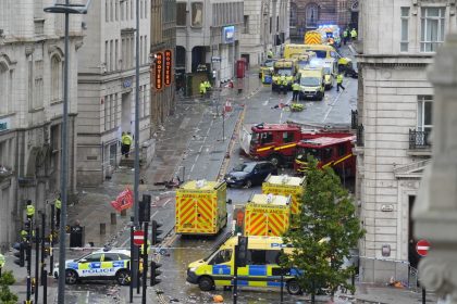 Emergency personnel work at the scene where a driver plowed a car into a parade in Liverpool, England, on Monday.