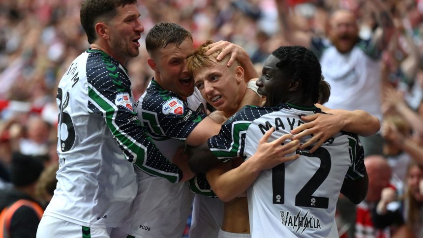 Tom Watson celebrates with his teammates after scoring an injury-time winner.