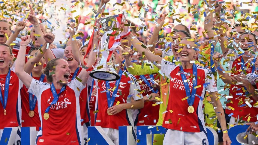 Kim Little (left) and Leah Williamson (right) lift the Women's Champions League trophy after their win.