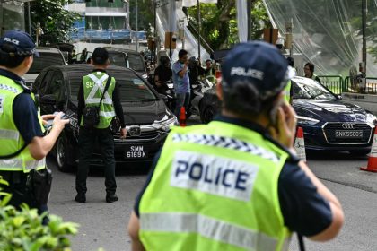 Police keep watch on vehicles entering the venue of the Shangri-La Dialogue in Singapore on Friday.