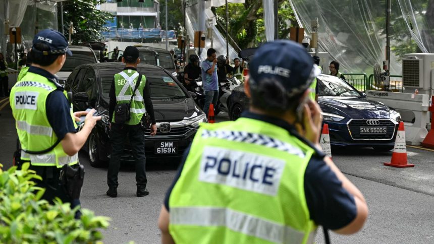 Police keep watch on vehicles entering the venue of the Shangri-La Dialogue in Singapore on Friday.