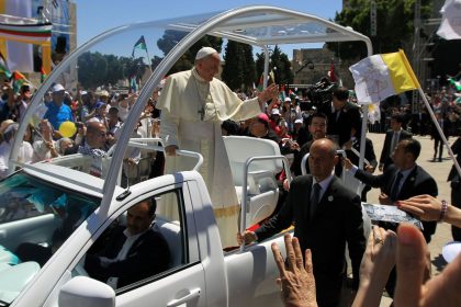 Pope Francis waves to the crowd, from his popemobile, as he arrives at the Manger Square for an open-air mass on May 25, 2014, outside the Church of the Nativity in Bethlehem, in the occupied West Bank.