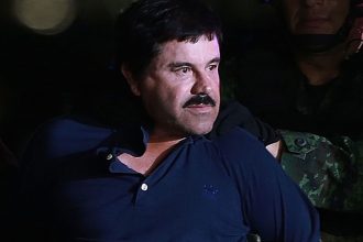 Cartel boss Joaquin Guzman is escorted by Mexican security forces at a Navy hangar in Mexico City, Mexico, on Jan. 8, 2016.