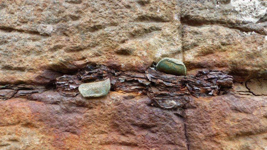 Coins in a crevice between two stones at Giant's Causeway