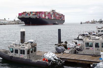 A cargo ship arriving at the Port of Los Angeles. Nearby are bonded warehouses where businesses pay money to have imports locked up to defer tariff payments.