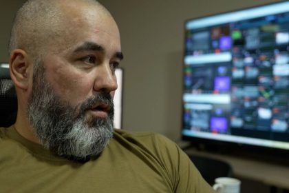 “Kir," a member of the National Guard of Ukraine, sits by a monitor showing a number of camera feeds.