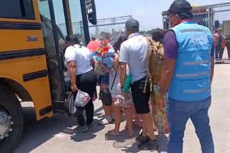 Migrants who self-deported from the US board a bus in Honduras after landing at a local airport.